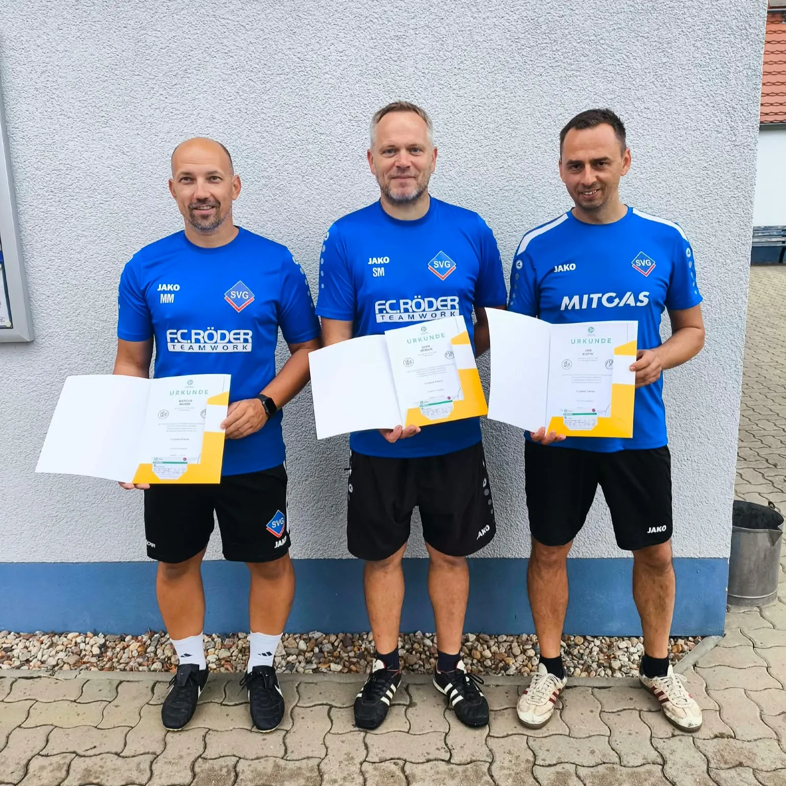 Drei neu ausgebildete Fußballtrainer erhalten ihre Lizenz
